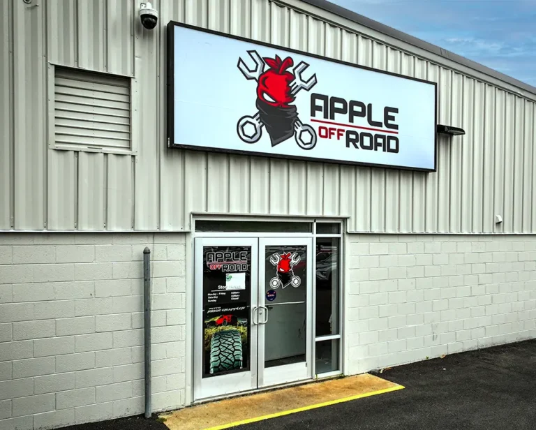 The Apple Off Road storefront sign with the red apple and crossed-wrench logo.